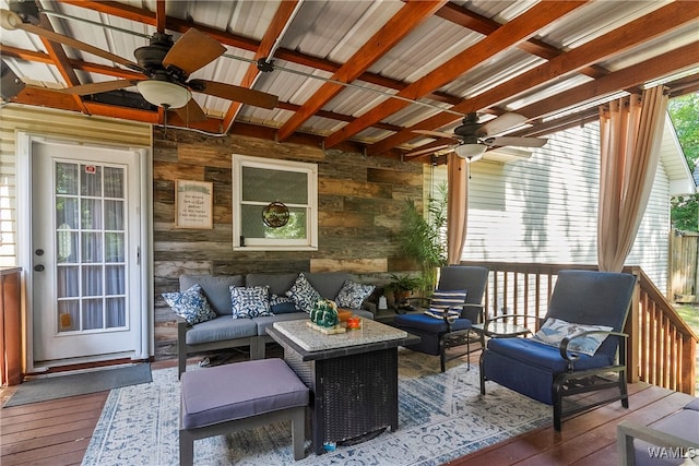 sunroom featuring beamed ceiling, a wealth of natural light, and ceiling fan