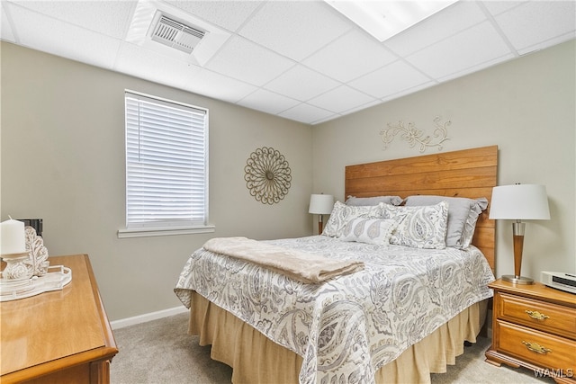 bedroom featuring a paneled ceiling and light colored carpet