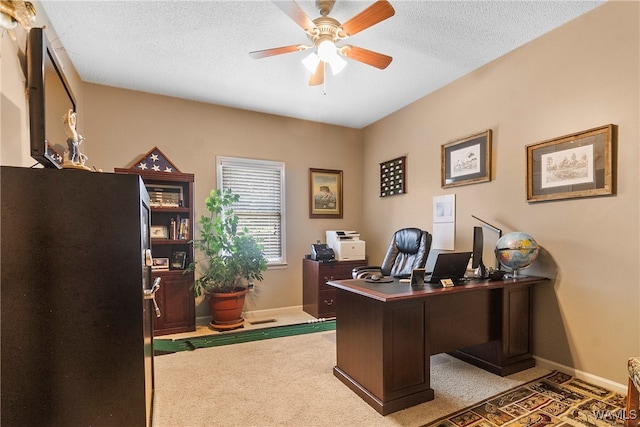 carpeted office featuring a textured ceiling and ceiling fan