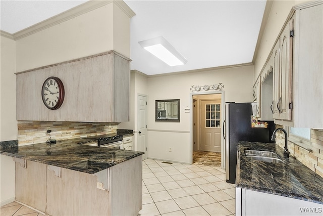 kitchen featuring kitchen peninsula, backsplash, dark stone counters, ornamental molding, and sink