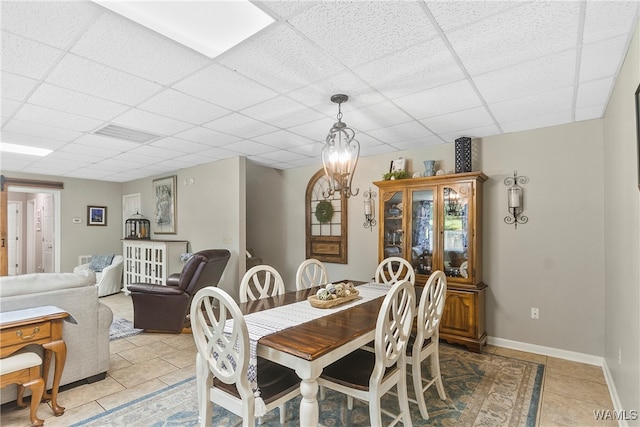 tiled dining room with a paneled ceiling