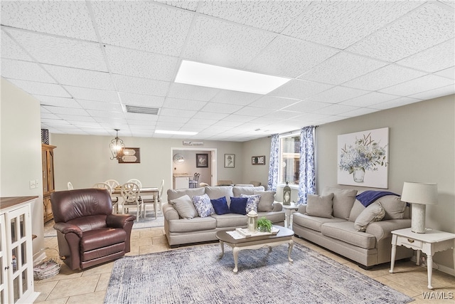 living room featuring a paneled ceiling and light tile patterned floors