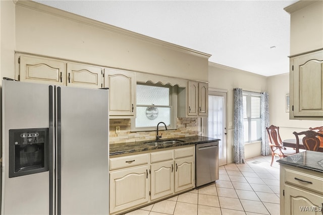 kitchen with sink, appliances with stainless steel finishes, decorative backsplash, light tile patterned floors, and ornamental molding