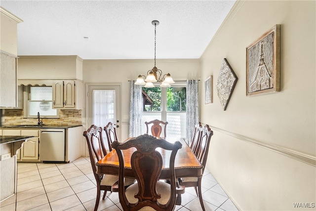 tiled dining space with a textured ceiling, crown molding, a notable chandelier, and sink