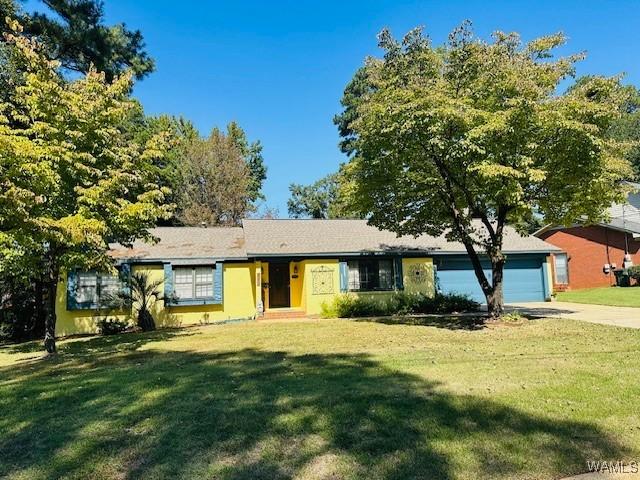 single story home with an attached garage, concrete driveway, and a front lawn