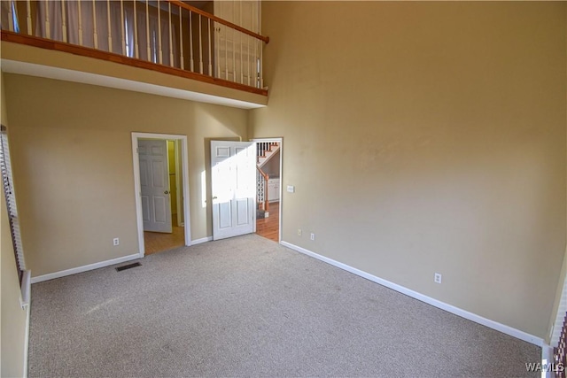 carpeted empty room with a towering ceiling