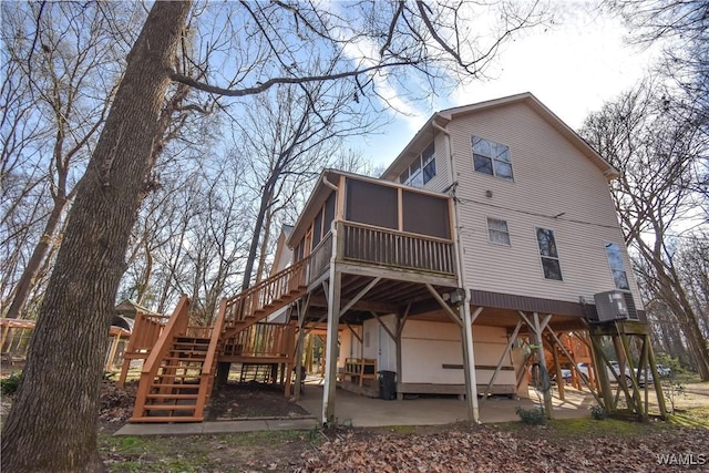 back of house with a patio area, a sunroom, and central AC