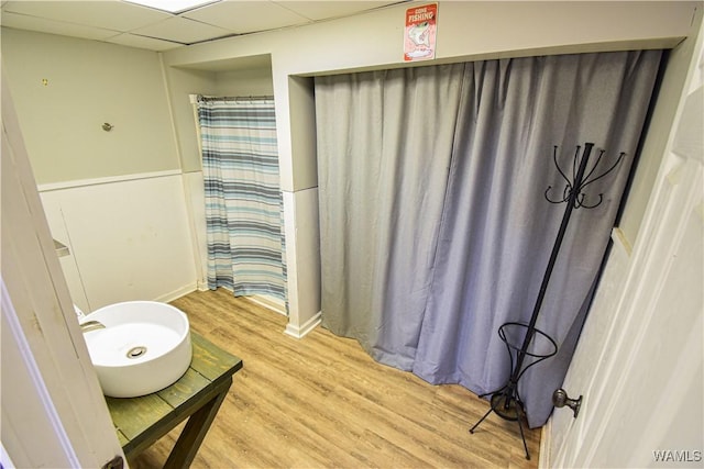 bathroom featuring a drop ceiling and hardwood / wood-style floors