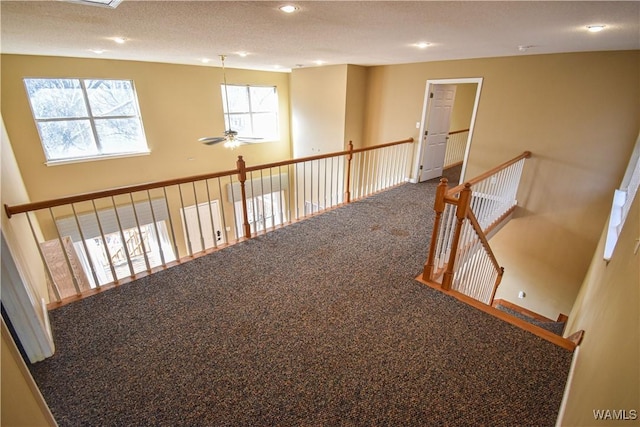 hall with carpet and a textured ceiling