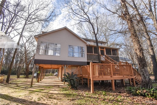 back of property featuring a wooden deck and a sunroom