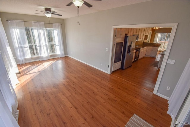 unfurnished living room featuring ceiling fan and light wood-type flooring