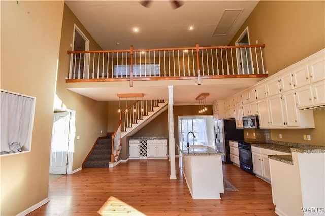 kitchen with white cabinetry, appliances with stainless steel finishes, decorative backsplash, decorative light fixtures, and sink