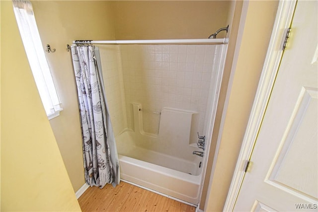 bathroom featuring hardwood / wood-style flooring and shower / bath combo with shower curtain