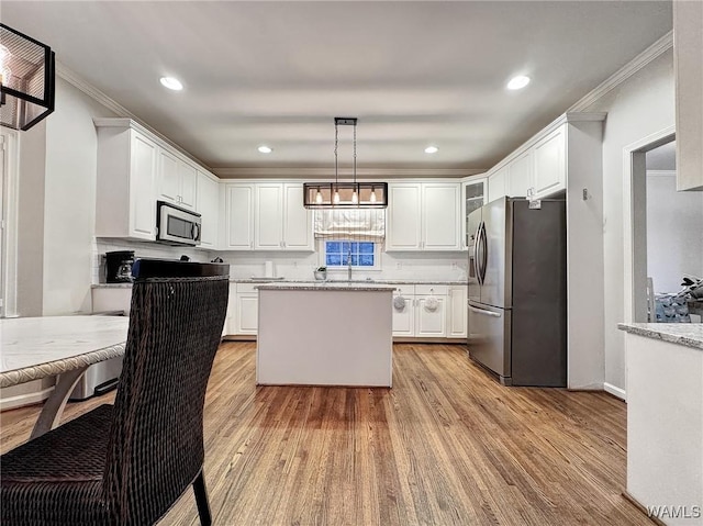 1851 Russet Woods Ln, Hoover, AL 35244 - kitchen featuring stainless steel appliances, ornamental molding, light wood-type flooring, white cabinets, and a kitchen island