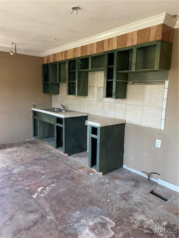 kitchen featuring a textured ceiling, visible vents, ornamental molding, and a sink
