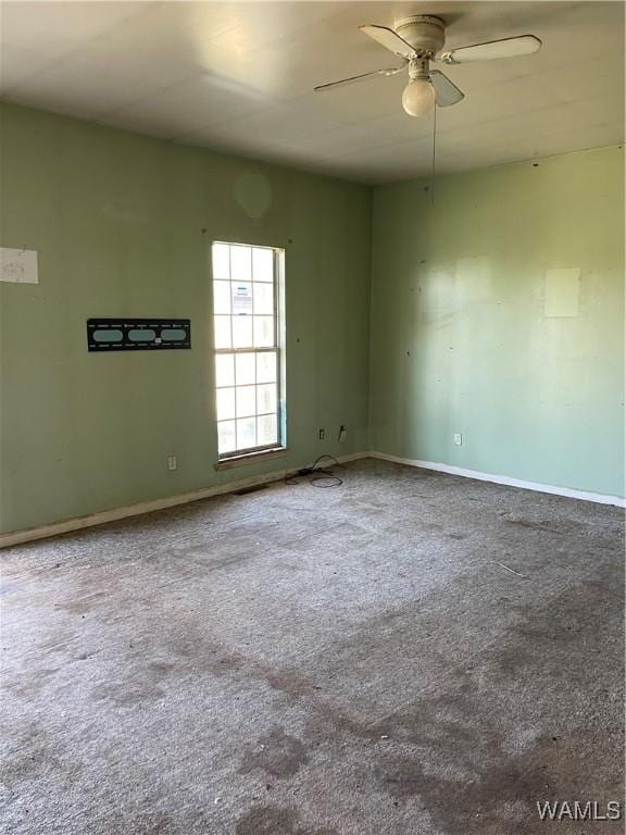 carpeted spare room with baseboards and ceiling fan
