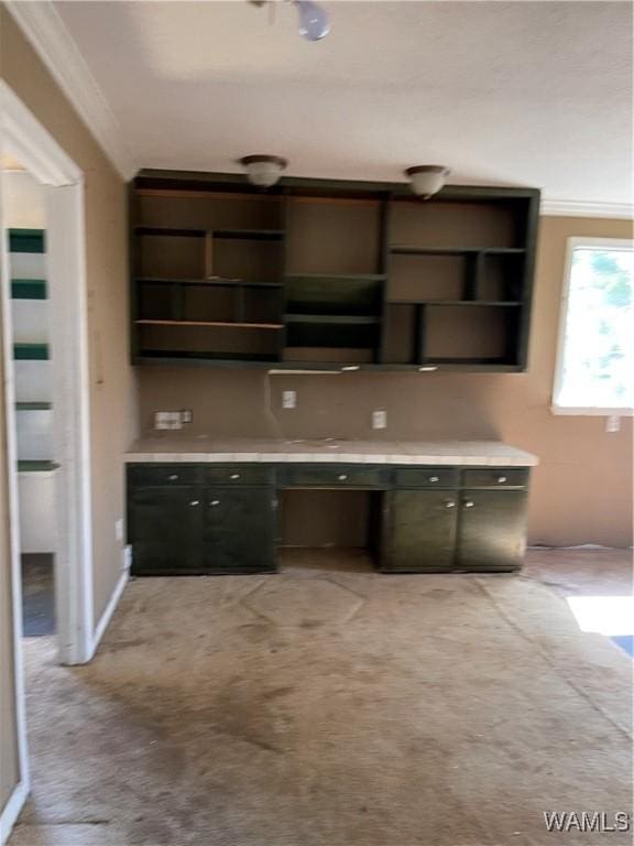 unfurnished office featuring built in study area, crown molding, and light carpet
