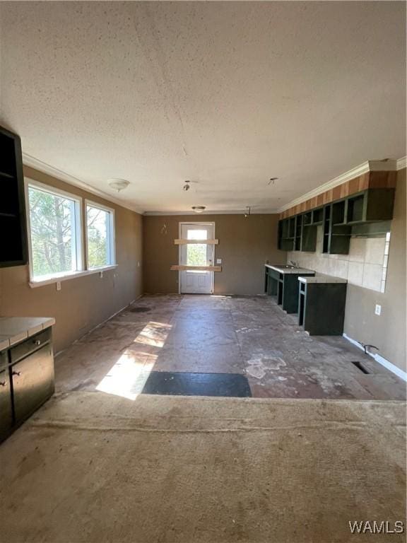 kitchen with a textured ceiling, ornamental molding, and open shelves