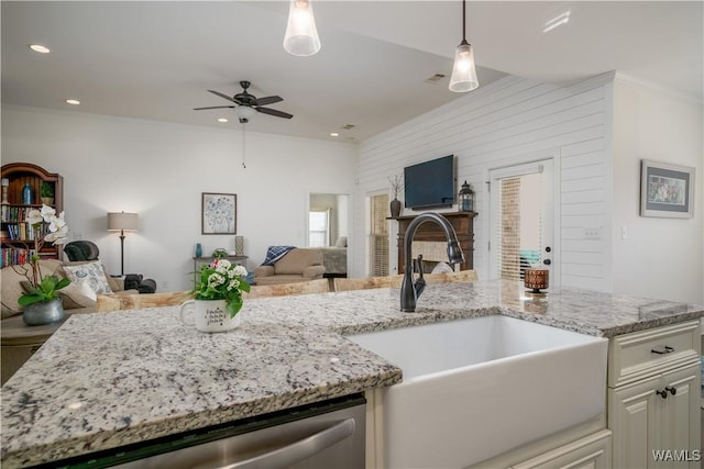 kitchen featuring dishwasher, light stone counters, open floor plan, a sink, and recessed lighting