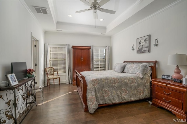 bedroom featuring dark wood-style flooring, recessed lighting, a raised ceiling, visible vents, and ornamental molding