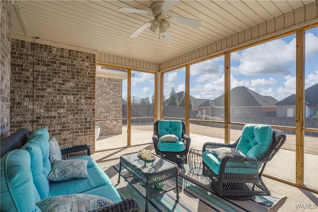 sunroom / solarium featuring ceiling fan and a residential view