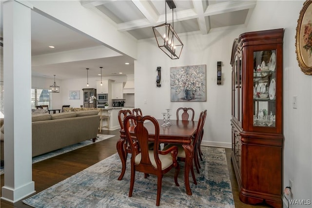 dining room with dark wood-style floors, a notable chandelier, coffered ceiling, beamed ceiling, and baseboards