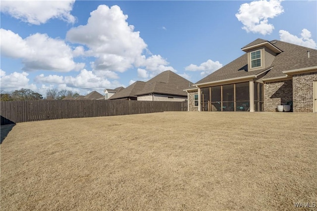 view of yard featuring a fenced backyard and a sunroom