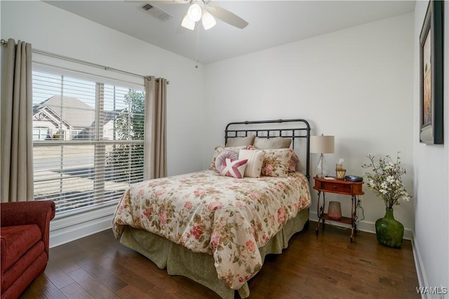 bedroom with ceiling fan, wood finished floors, visible vents, and baseboards