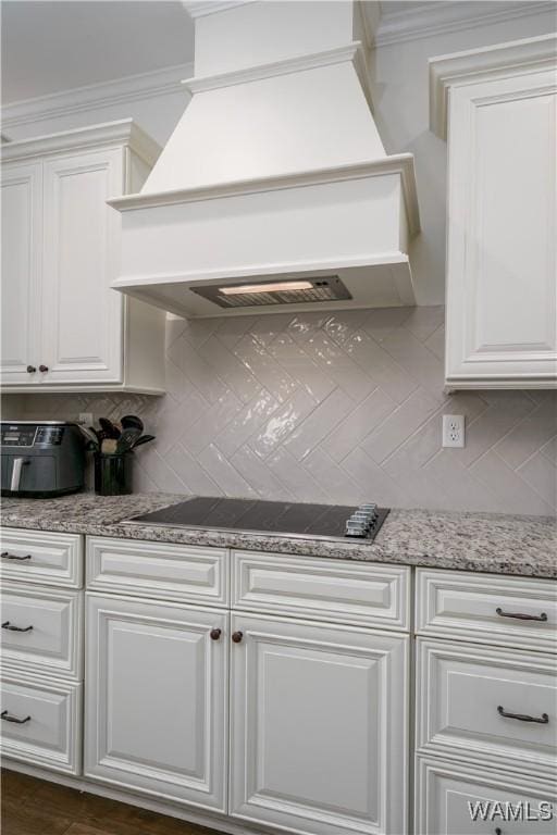 kitchen with crown molding, black electric stovetop, custom exhaust hood, and tasteful backsplash