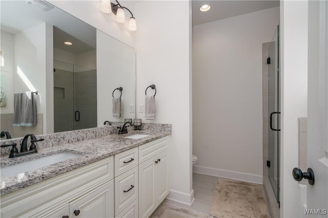 full bath with double vanity, a stall shower, a sink, and toilet