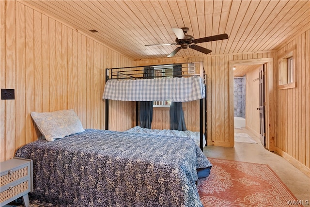 bedroom featuring concrete flooring, ceiling fan, wooden ceiling, and wood walls