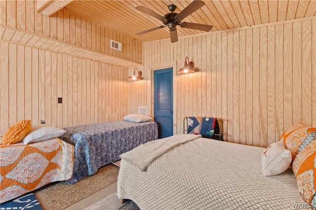 bedroom with ceiling fan, wood walls, and wooden ceiling