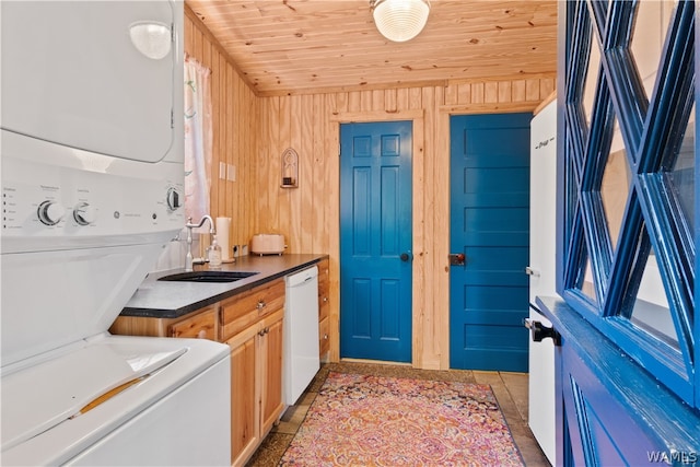 laundry area featuring sink, wood walls, light tile patterned floors, wood ceiling, and stacked washer and clothes dryer