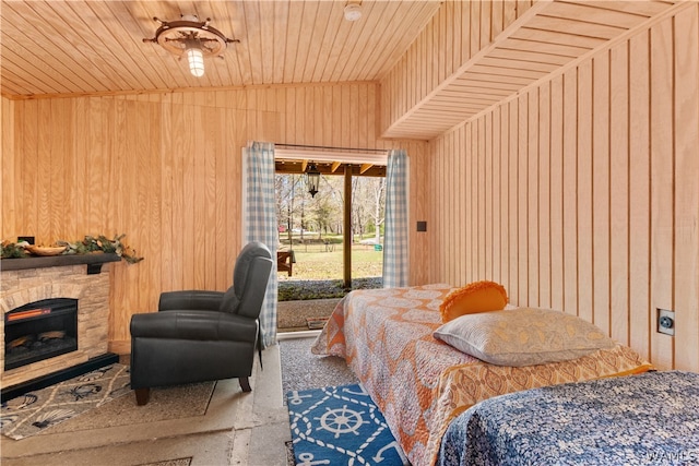 bedroom featuring wooden walls, a fireplace, and wood ceiling