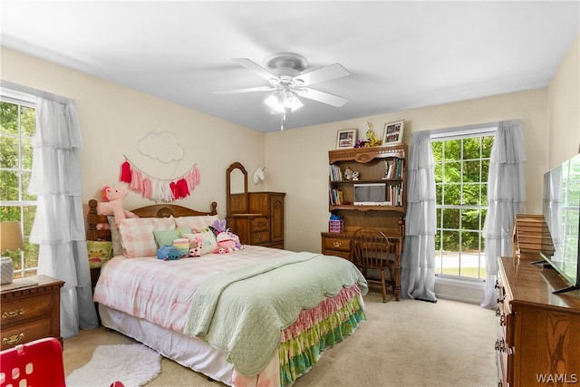 bedroom with light carpet, multiple windows, and ceiling fan