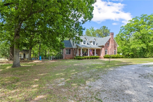 cape cod-style house with covered porch and a front lawn