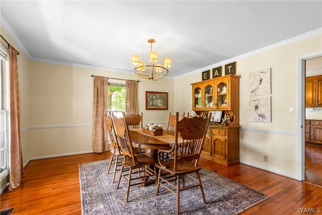 dining area with crown molding, dark hardwood / wood-style floors, and an inviting chandelier