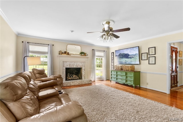 living room with a fireplace, hardwood / wood-style floors, plenty of natural light, and ornamental molding