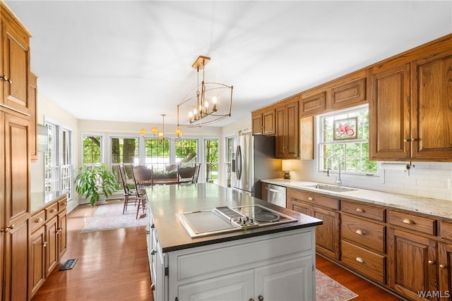 kitchen featuring dark hardwood / wood-style flooring, an inviting chandelier, stainless steel appliances, and a kitchen island