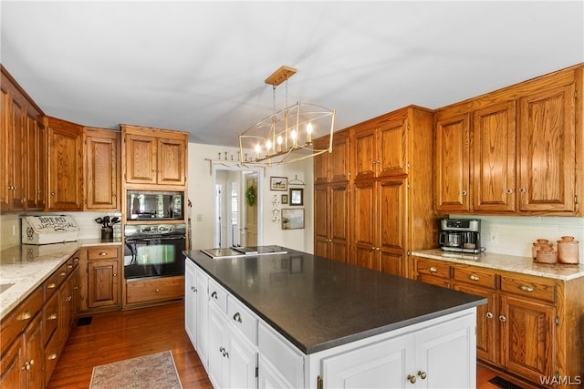 kitchen with white cabinetry, an inviting chandelier, decorative light fixtures, black appliances, and hardwood / wood-style flooring