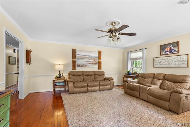 living room featuring dark hardwood / wood-style flooring, ceiling fan, and ornamental molding