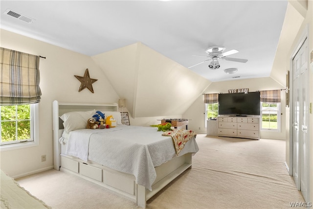 bedroom with multiple windows, ceiling fan, light colored carpet, and vaulted ceiling