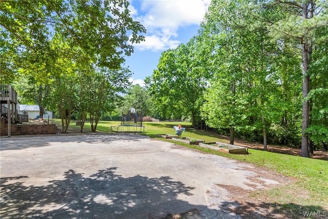 exterior space with a trampoline and a yard