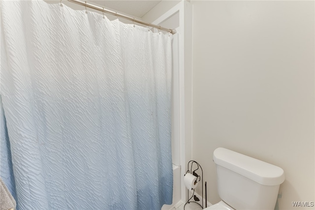 bathroom featuring walk in shower and toilet