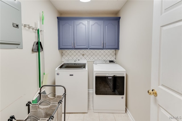 laundry room with washer and dryer, light tile patterned floors, and cabinets