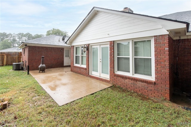 back of property with a patio, a yard, and central air condition unit