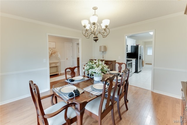 dining space featuring ornamental molding, light hardwood / wood-style floors, and a chandelier