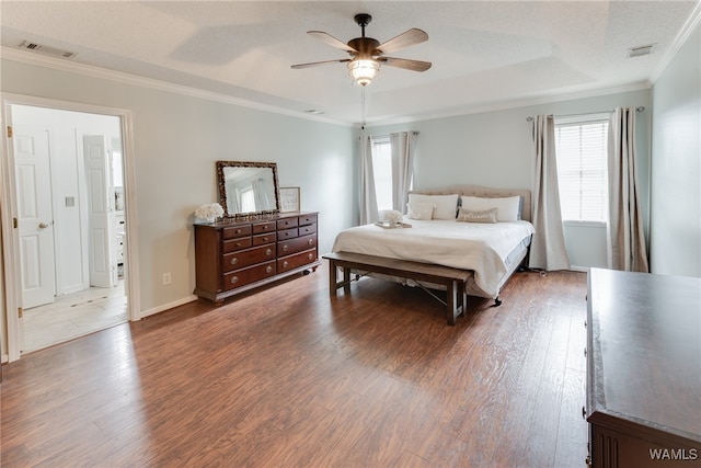 bedroom featuring wood-type flooring, ceiling fan, a raised ceiling, crown molding, and a textured ceiling