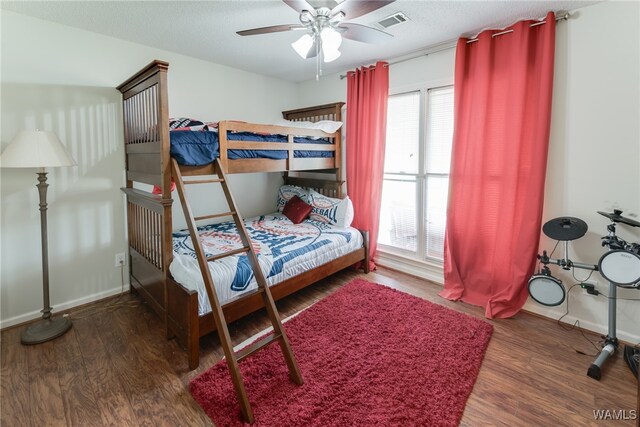 bedroom with ceiling fan, a textured ceiling, and dark hardwood / wood-style flooring