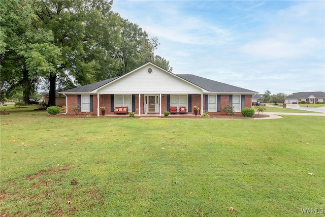 ranch-style house featuring covered porch and a front yard